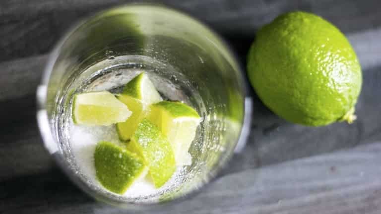 Preparazione della Caipirissima con lime e zucchero nel bicchiere. Cocktail.