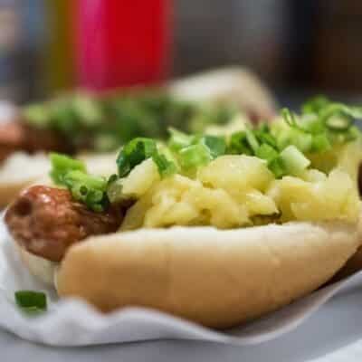 Hot dog gourmet con ananas, cipollotti, salsa teriyaki e bacon. Ricetta hot dog