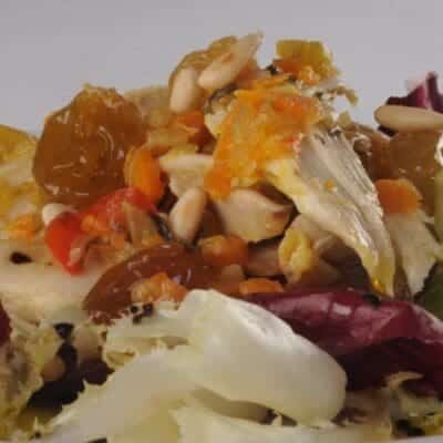 Antipasti gourmet insalata di cappone con uvetta, pinoli e aceto balsamico tradizionale di Modena