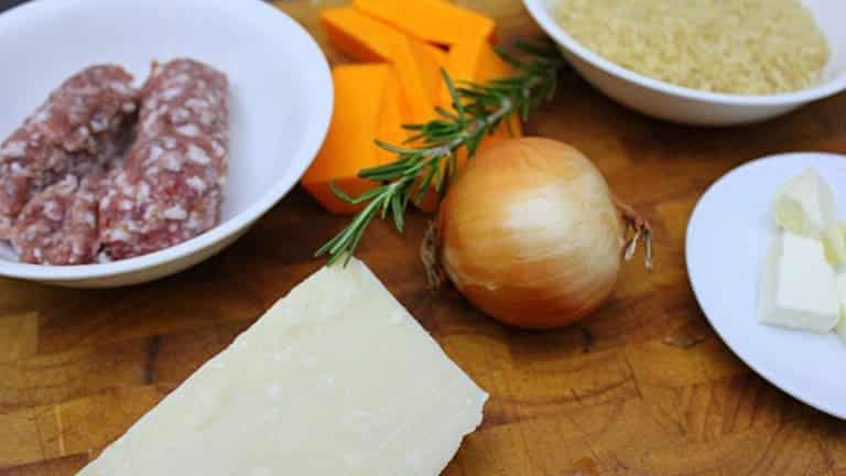 Ingredients for making pumpkin and sausage risotto: rosemary, Parmesan, onion