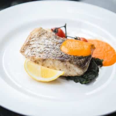 Filetto di branzino alla griglia con salsa d'arancia e pepe di Giamaica. Ricetta