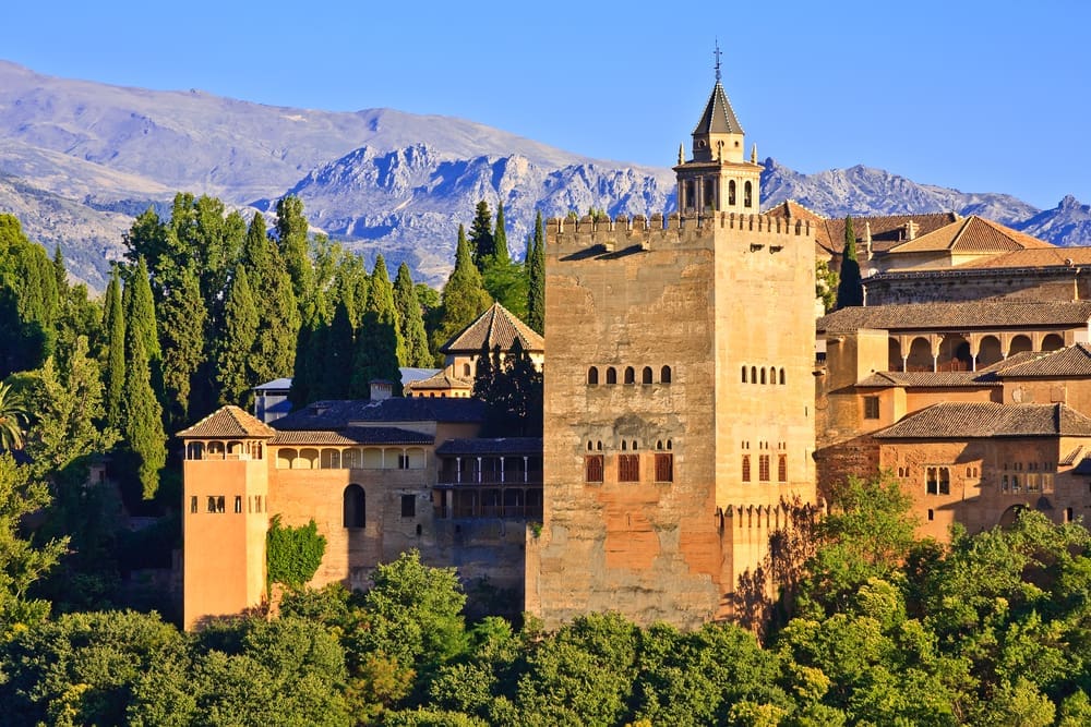 Image of the majestic Alhambra palace in Granada, Spain, showcasing its intricate Islamic architecture and lush green gardens.