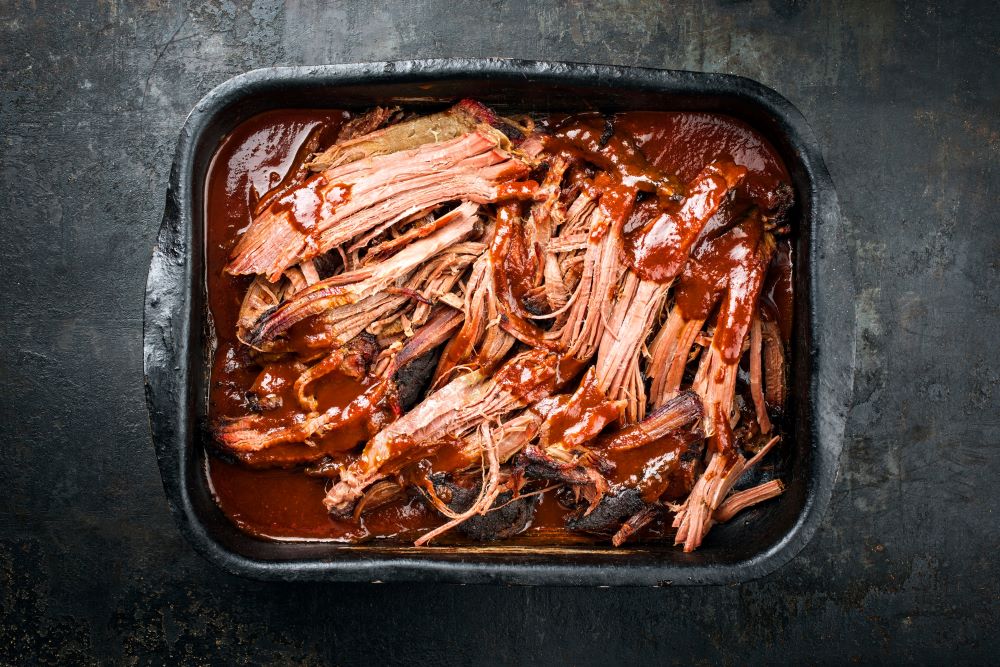 Pulled pork al forno con salsa agrodolce: la ricetta per fare un maiale sfilacciato succulento e delizioso